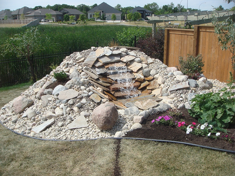 Backyard waterfall with riverwash ground cover