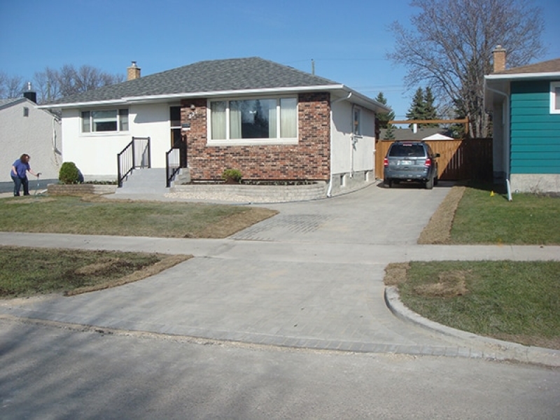 Holland paver driveway and front walk. Roman stack stone retaining wall bricks. Black aluminum railing bolted to existing front step.