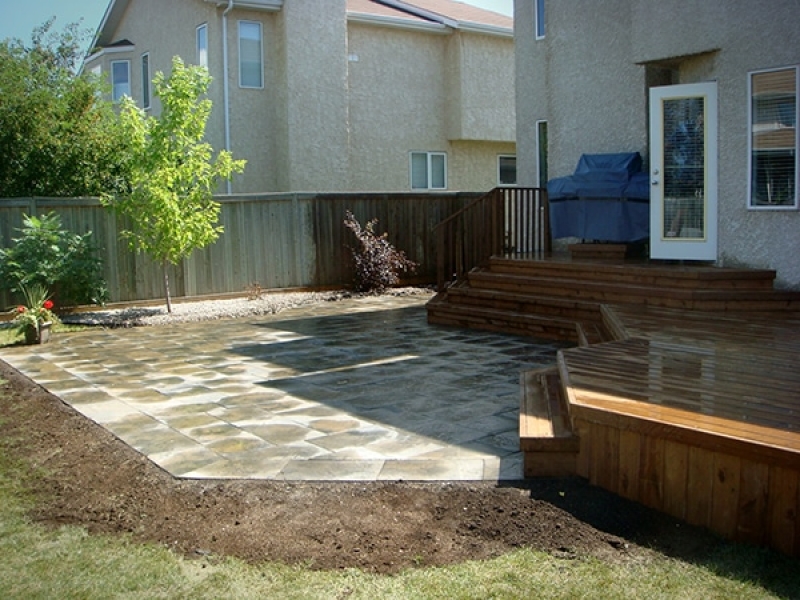 Treated brown deck with full length staircase leading to partially wet Dynasty slate patio.