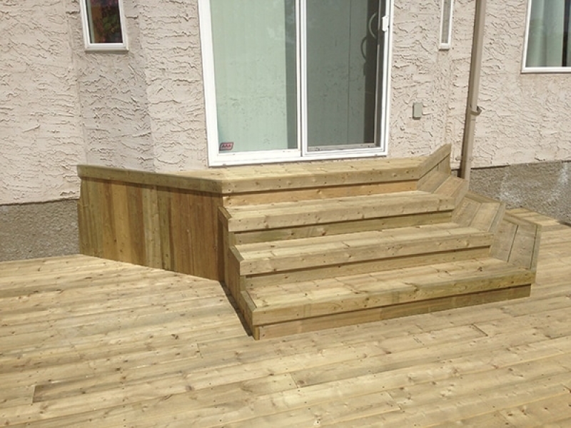 Treated green deck with decorative steps to door, Dynasty Slate patio.