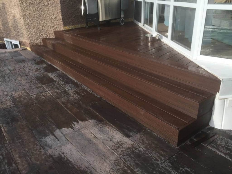 Bridgewood slab patio in cedar brown with Trex composite stairs and treated brown gazebo roof