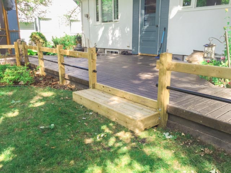 Treated green railing with black horizontal pipe