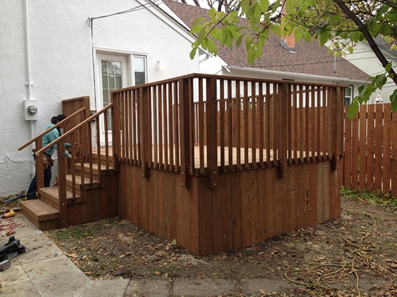 Rectangular treated brown deck with basic railing