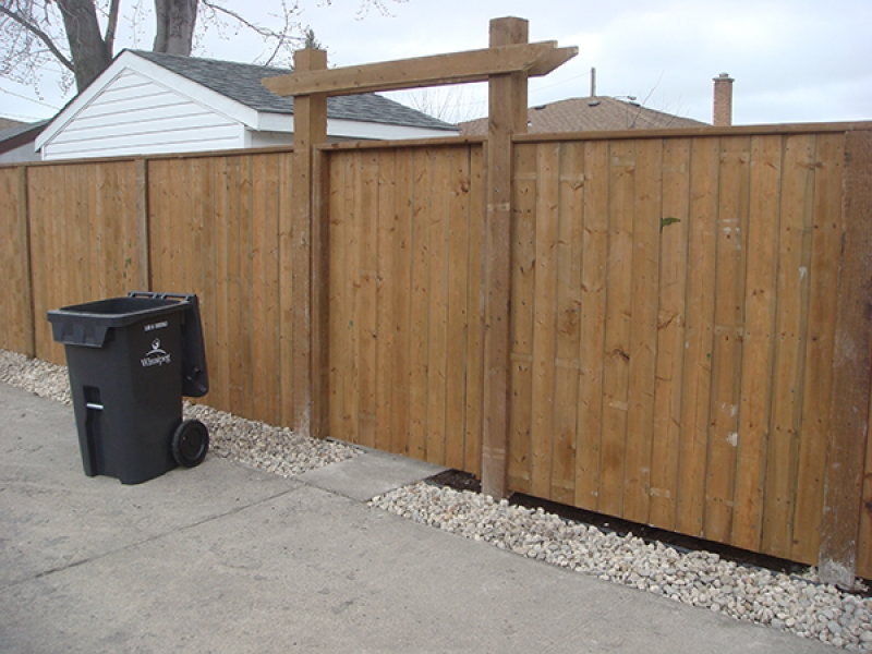 Flagstone paver patio in Sierra Grey. Treated brown fence with 6x6 posts and gate crossbar. Lattice privacy wall (Outdoor Wood Structure)