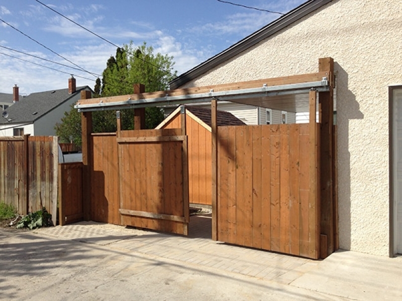 Wooden shed, fence with vehicle access gate, dual use parking pad