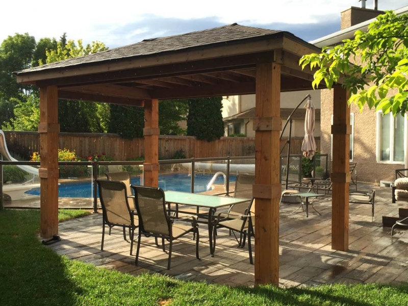 Bridgewood slab patio in cedar brown with Trex composite stairs and treated brown gazebo roof