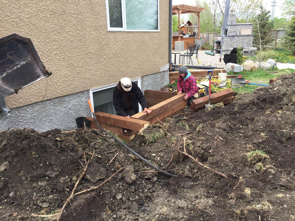 Swim spa pad, large window wells, re-grading, flagstone pathway, and decorative stone