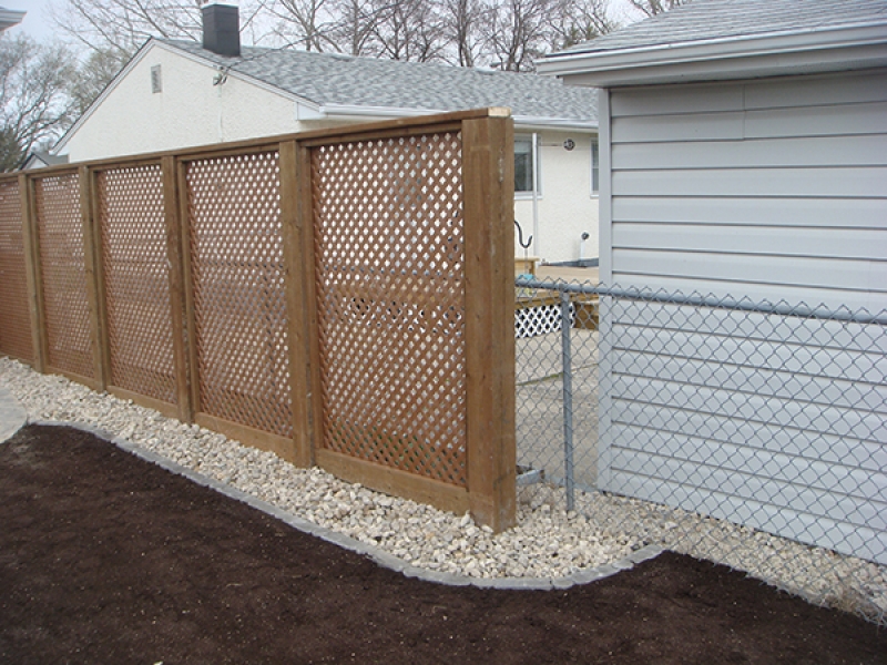 Flagstone paver patio in Sierra Grey. Treated brown fence with 6x6 posts and gate crossbar. Lattice privacy wall (Outdoor Wood Structure)