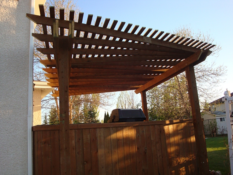 Treated brown deck with built-in cabinets, counters, benches, and pergola (Outdoor Wood Structure)