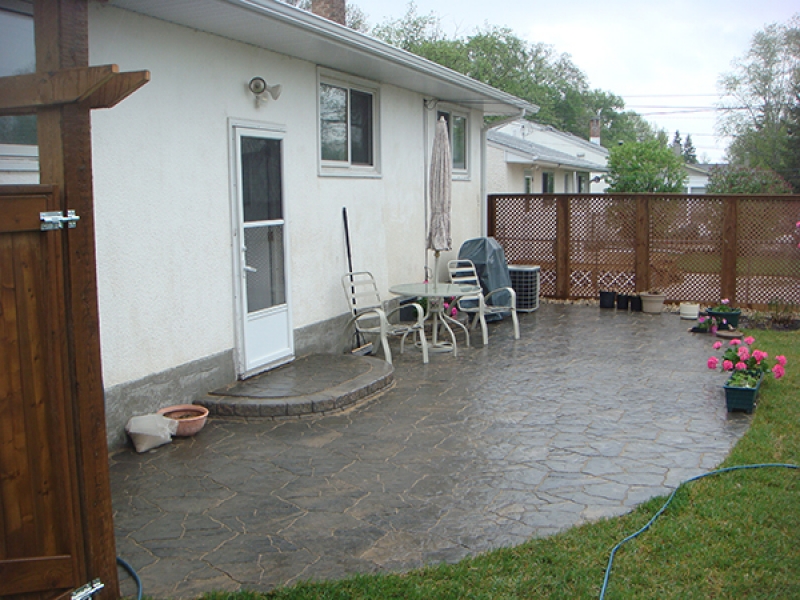 Flagstone paver patio in Sierra Grey. Treated brown fence with 6x6 posts and gate crossbar. Lattice privacy wall (Outdoor Wood Structure)