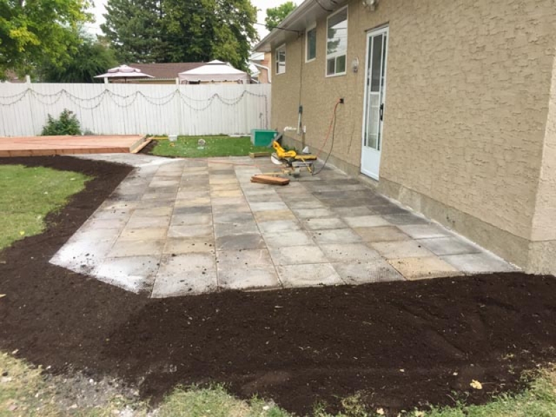 Used patio block re-installation and new ground-level deck in treated brown