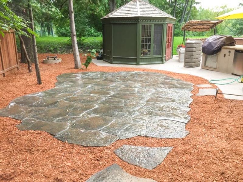 Grand Flagstone patio in Copper Canyon with orange wood mulch