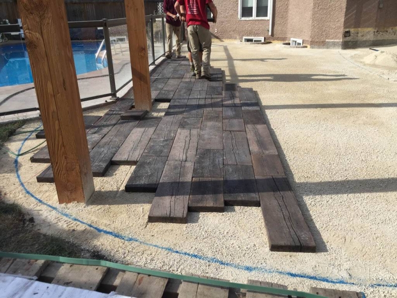 Bridgewood slab patio in cedar brown with Trex composite stairs and treated brown gazebo roof