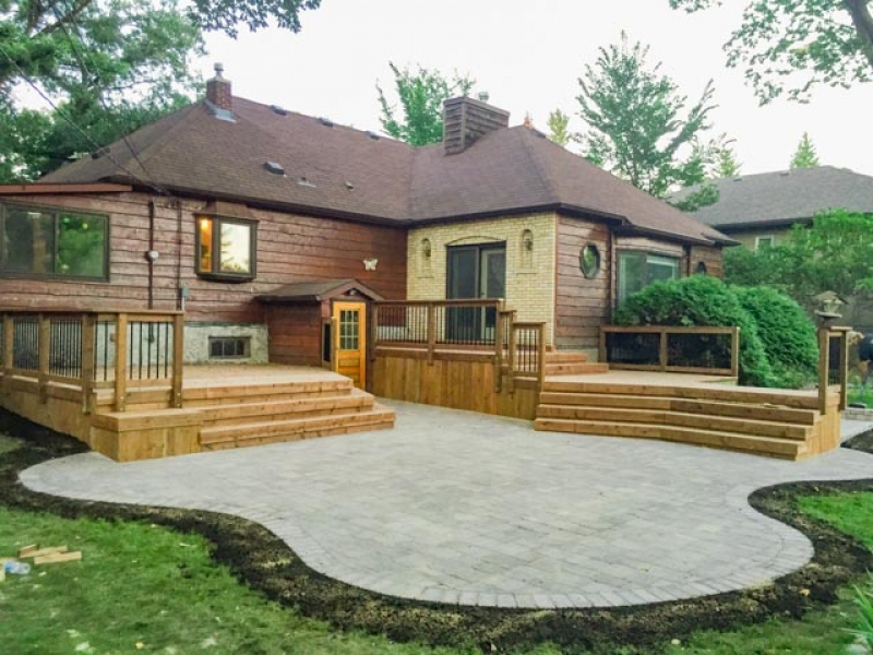 Two treated brown decks with roman paving stone patio