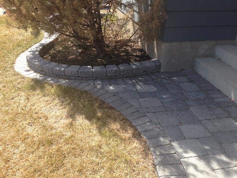 Roman Stack Stone retaining wall with Roman pavers at base to facilitate mowing