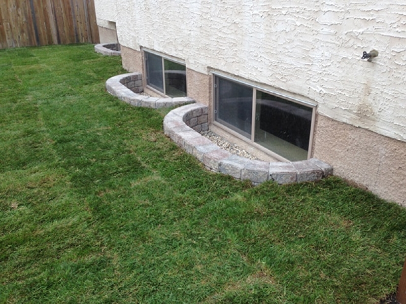Composite deck, retaining wall window wells, patio, sod