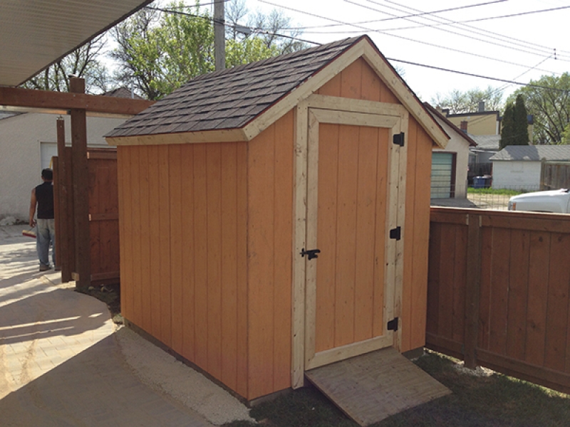 Wooden shed, fence with vehicle access gate, dual use parking pad