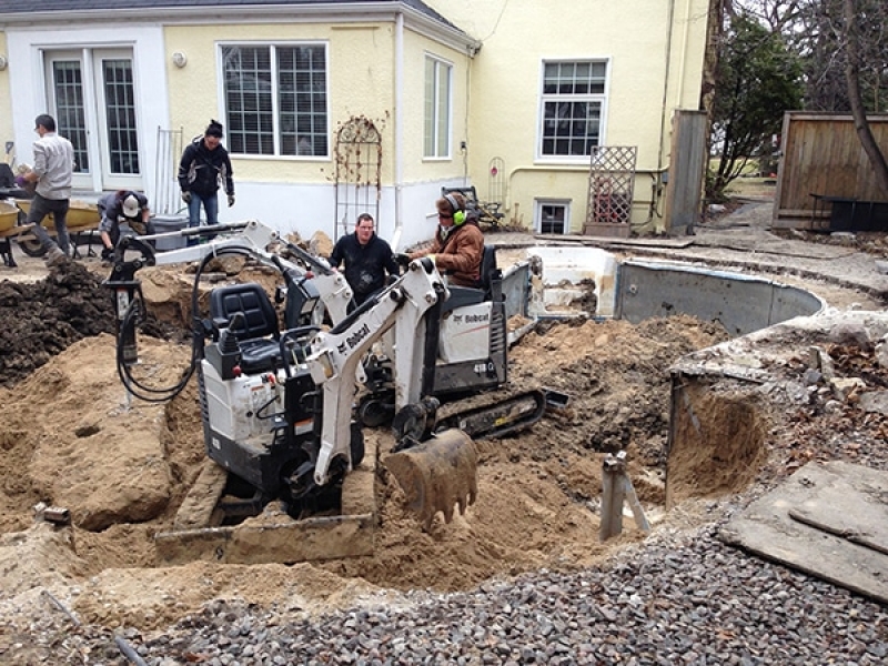 Swimming pool removal with mini excavators and wheelbarrows