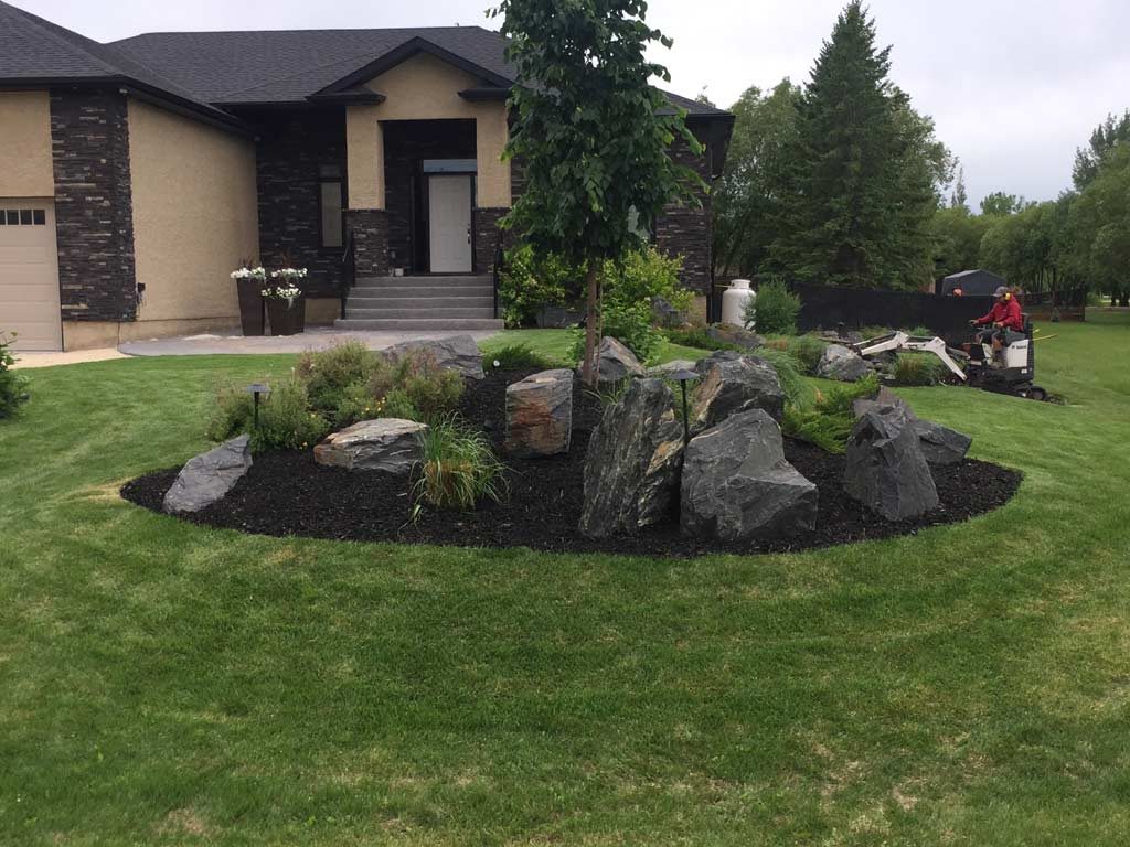 Complete yard installation. Two tier treated brown deck with built-in hot tub and storage access door, patio with fire pit and seating wall, black granite boulders, mulch, lighting, arbors