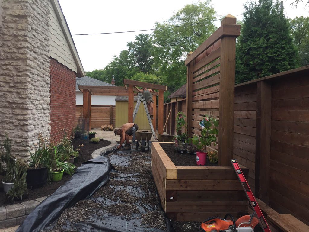 Treated brown pergola with hanging bench, fixed bench, Roman paving stones, planter with trellis, etc