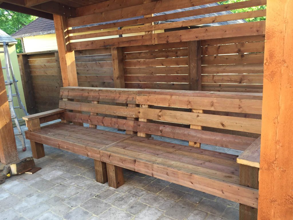 Treated brown pergola with hanging bench, fixed bench, Roman paving stones, planter with trellis, etc