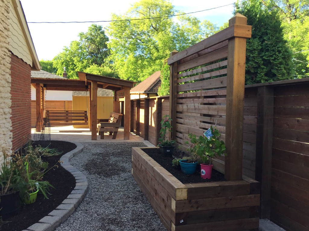 Treated brown pergola with hanging bench, fixed bench, Roman paving stones, planter with trellis, etc