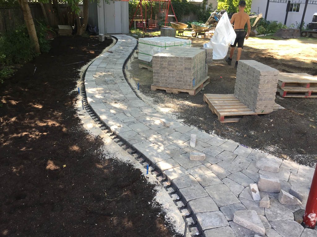 Complete yard re-grading with Roman paver walks, dry streambed, sod, etc