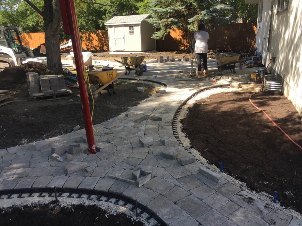 Complete yard re-grading with Roman paver walks, dry streambed, sod, etc