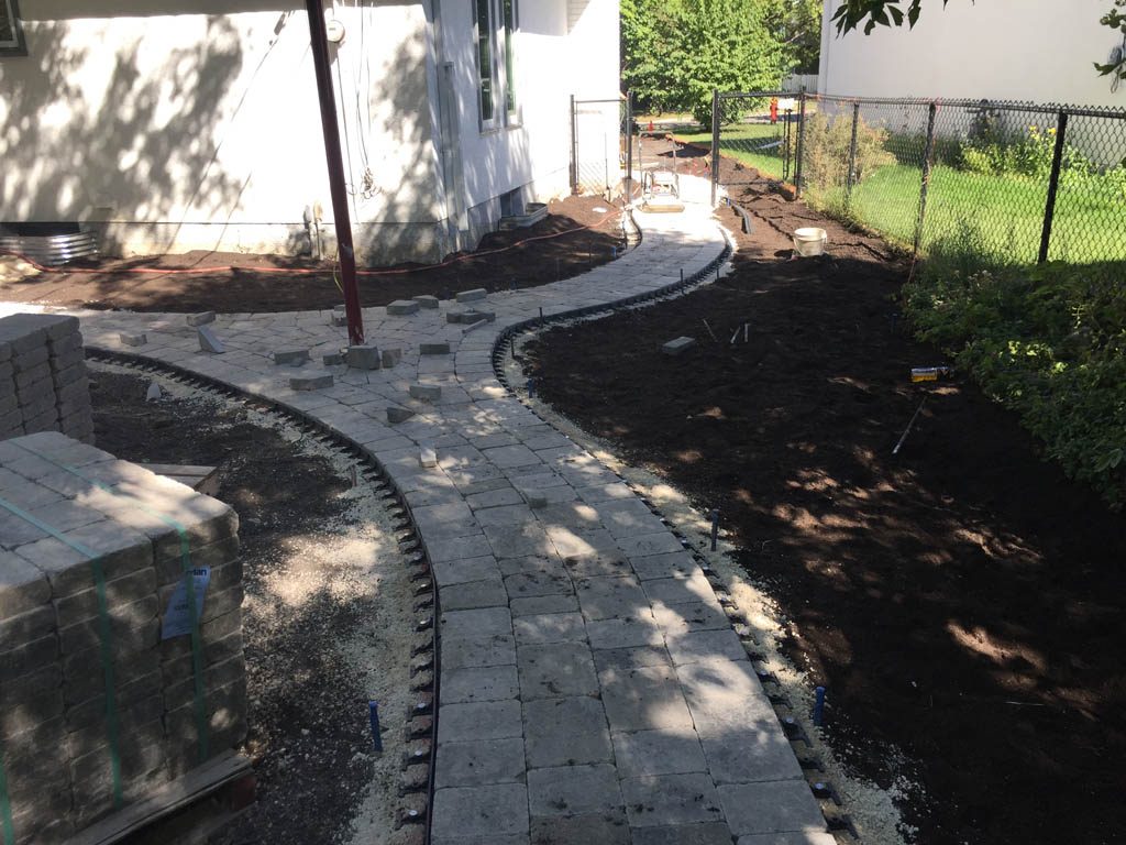 Complete yard re-grading with Roman paver walks, dry streambed, sod, etc