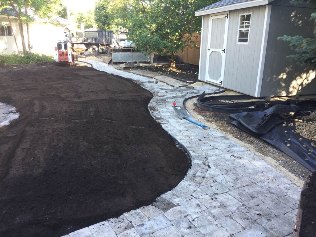 Complete yard re-grading with Roman paver walks, dry streambed, sod, etc