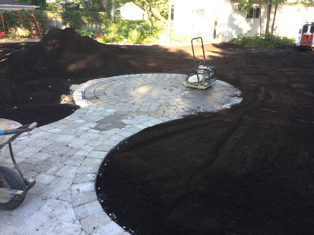 Complete yard re-grading with Roman paver walks, dry streambed, sod, etc