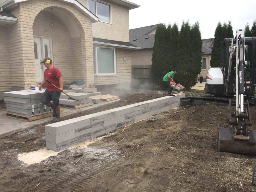 Front yard renovation with Architextures retaining wall, black granite, plants, sod