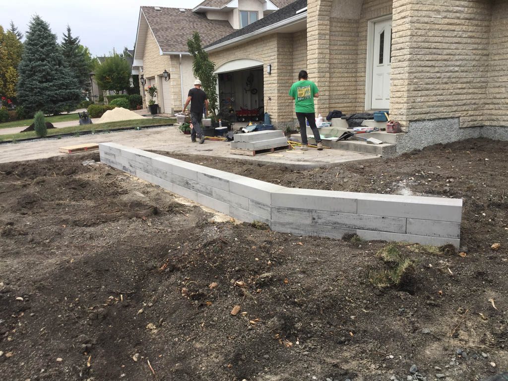 Front yard renovation with Architextures retaining wall, black granite, plants, sod