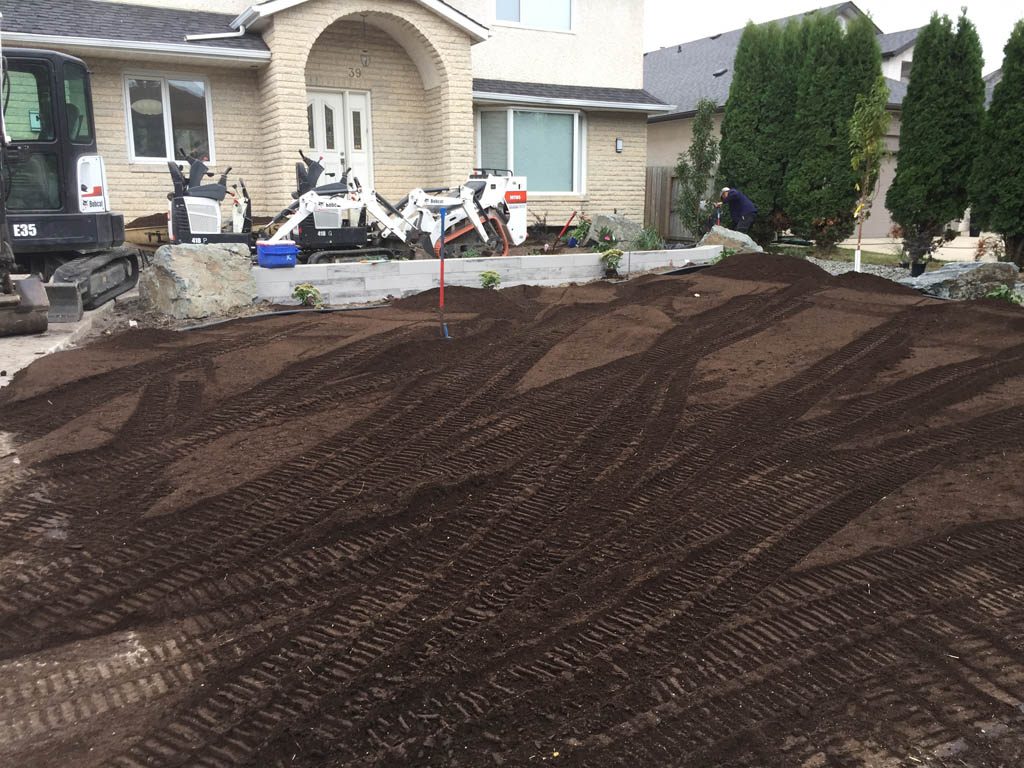 Front yard renovation with Architextures retaining wall, black granite, plants, sod