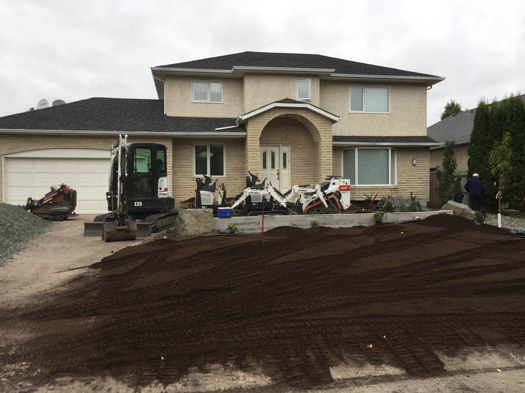 Front yard renovation with Architextures retaining wall, black granite, plants, sod