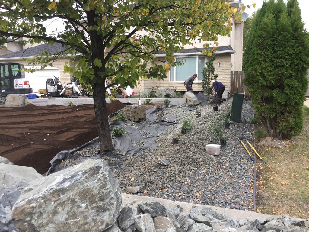 Front yard renovation with Architextures retaining wall, black granite, plants, sod