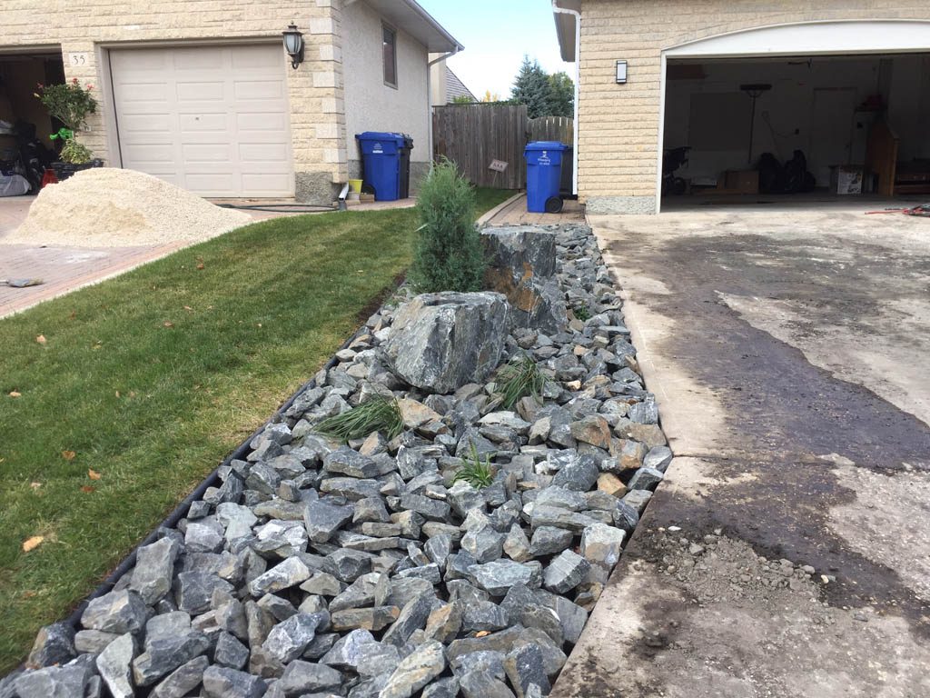 Front yard renovation with Architextures retaining wall, black granite, plants, sod