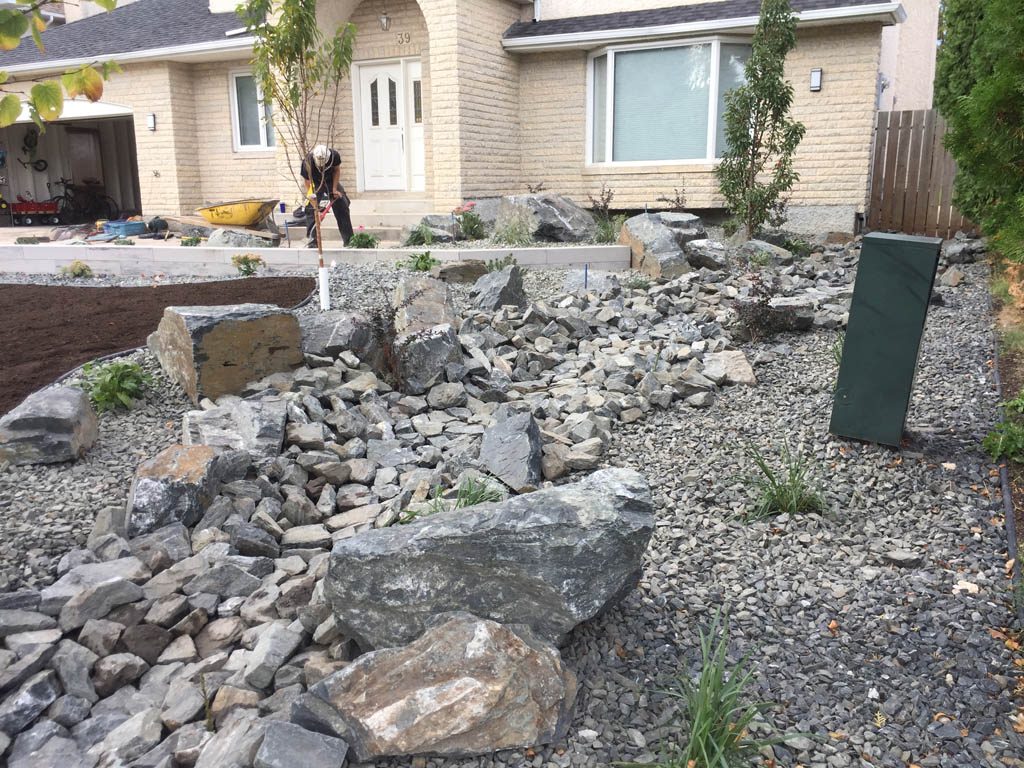 Front yard renovation with Architextures retaining wall, black granite, plants, sod