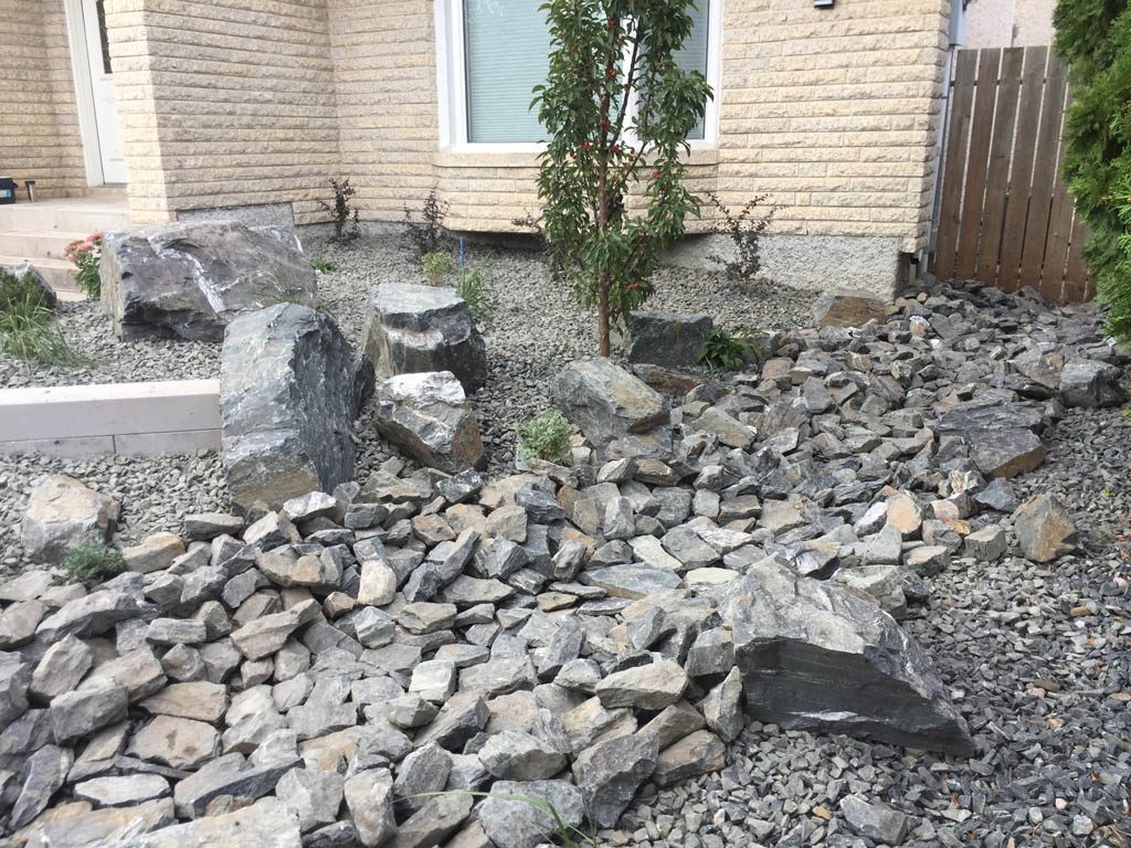 Front yard renovation with Architextures retaining wall, black granite, plants, sod