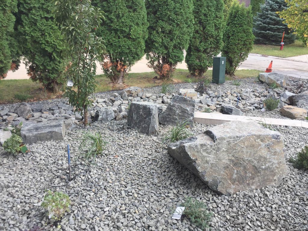 Front yard renovation with Architextures retaining wall, black granite, plants, sod