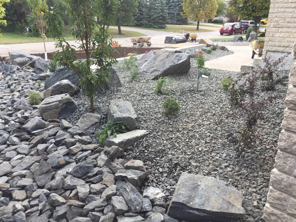 Front yard renovation with Architextures retaining wall, black granite, plants, sod