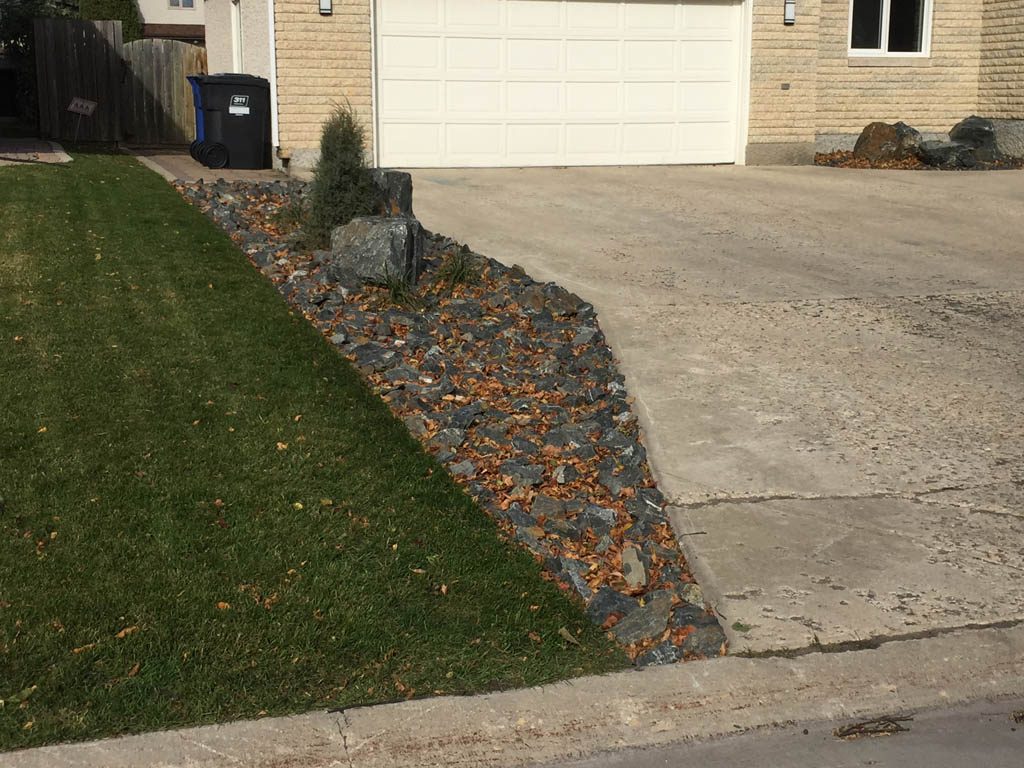 Front yard renovation with Architextures retaining wall, black granite, plants, sod