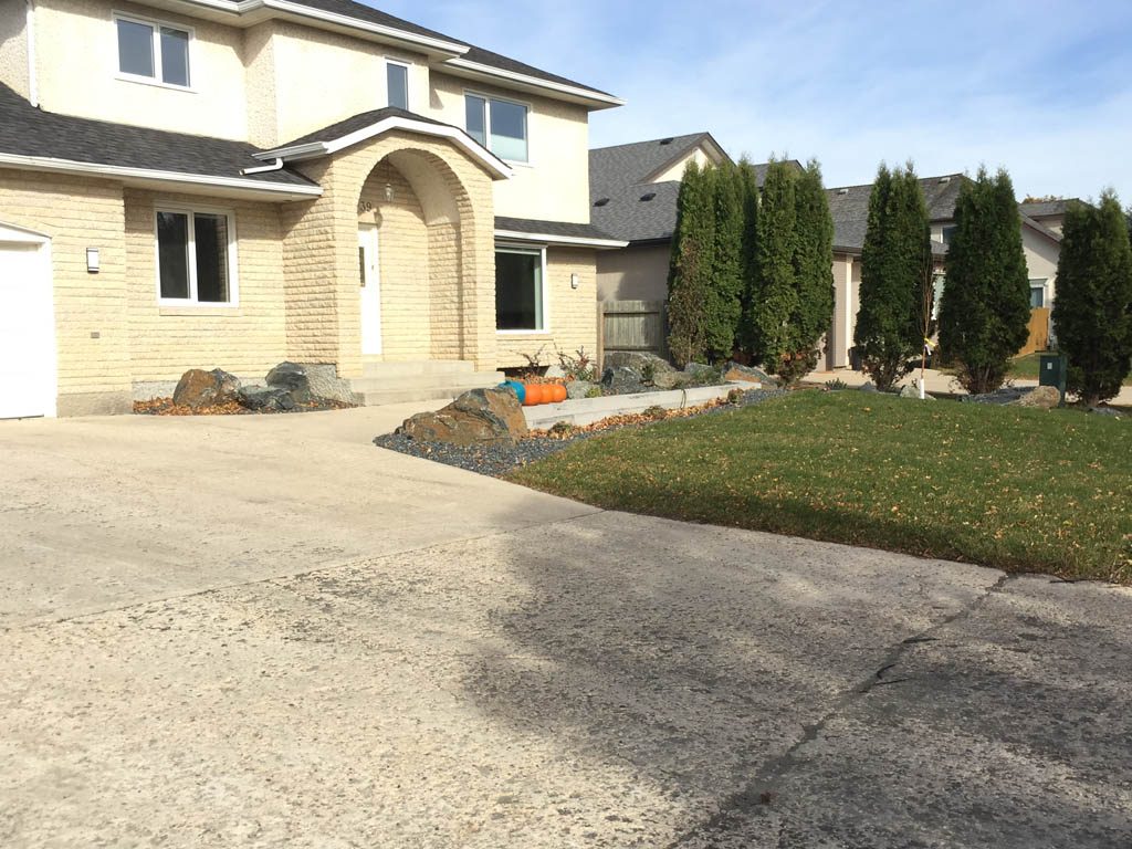 Front yard renovation with Architextures retaining wall, black granite, plants, sod