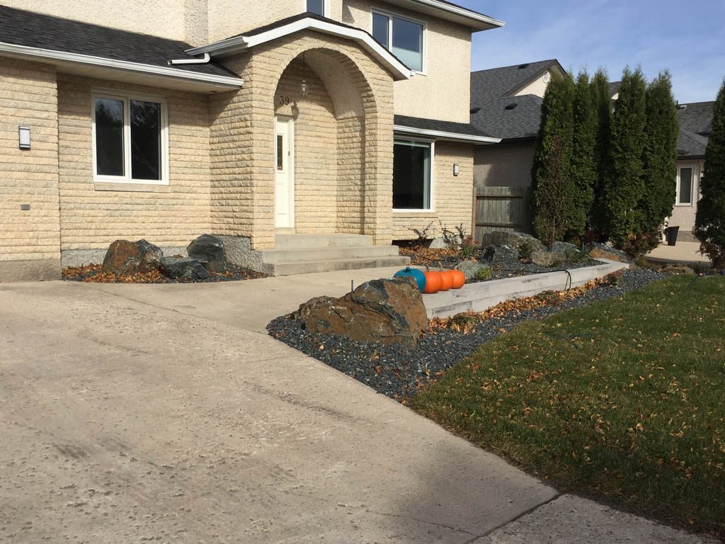 Front yard renovation with Architextures retaining wall, black granite, plants, sod