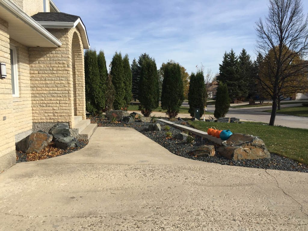 Front yard renovation with Architextures retaining wall, black granite, plants, sod