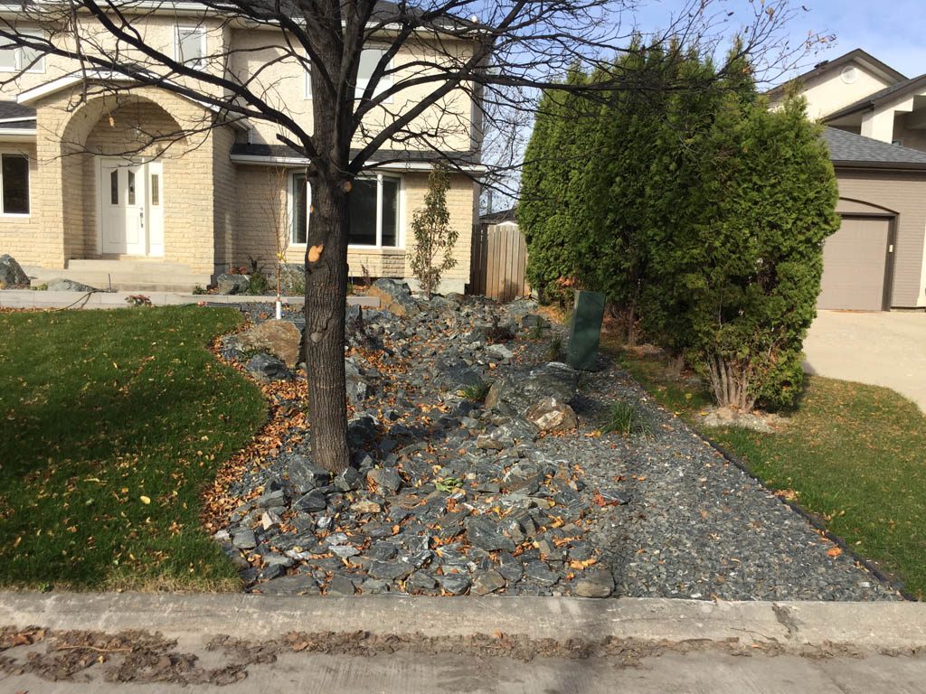 Front yard renovation with Architextures retaining wall, black granite, plants, sod