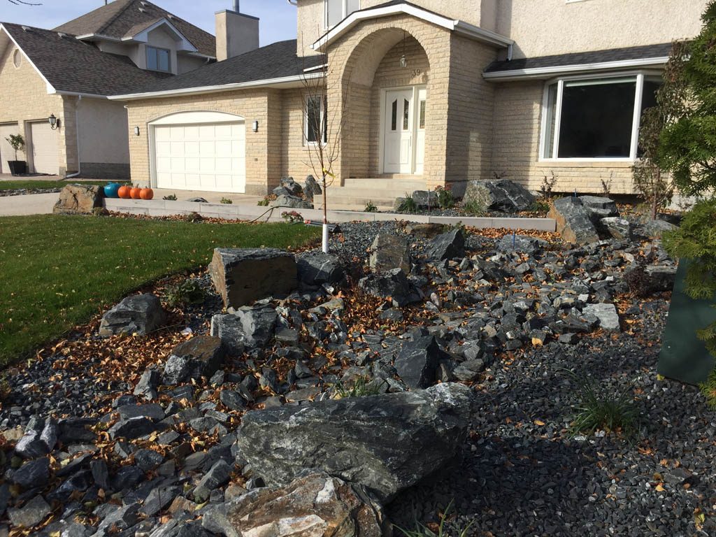 Front yard renovation with Architextures retaining wall, black granite, plants, sod