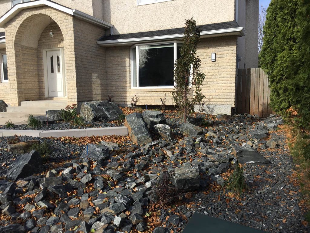 Front yard renovation with Architextures retaining wall, black granite, plants, sod