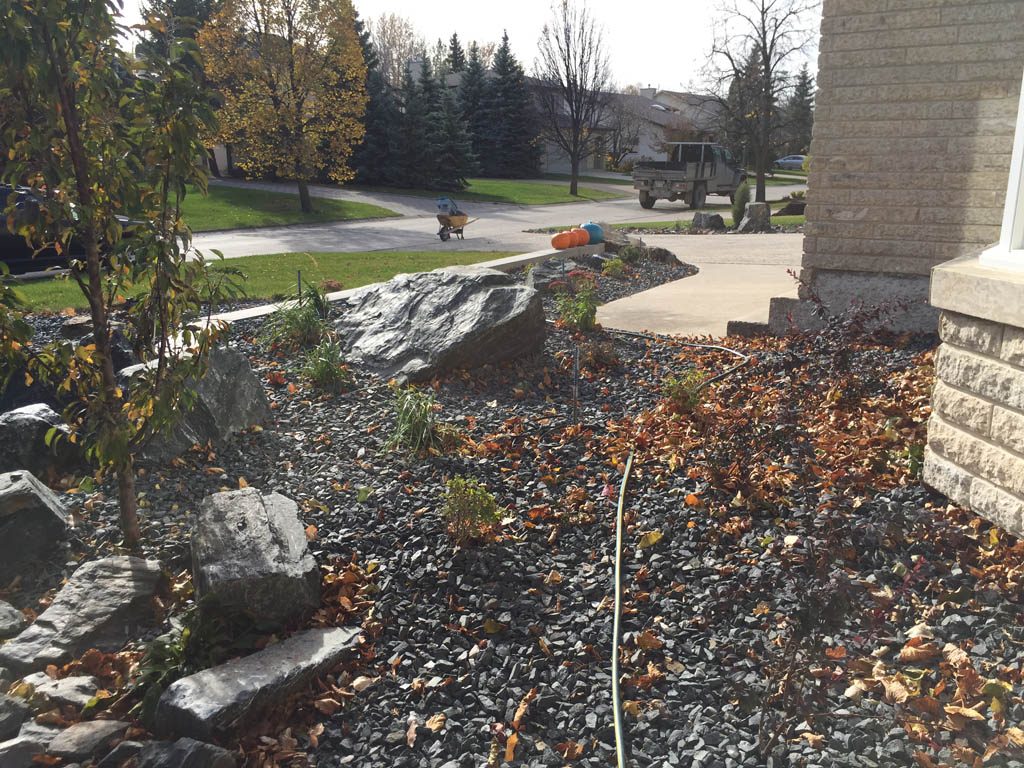 Front yard renovation with Architextures retaining wall, black granite, plants, sod