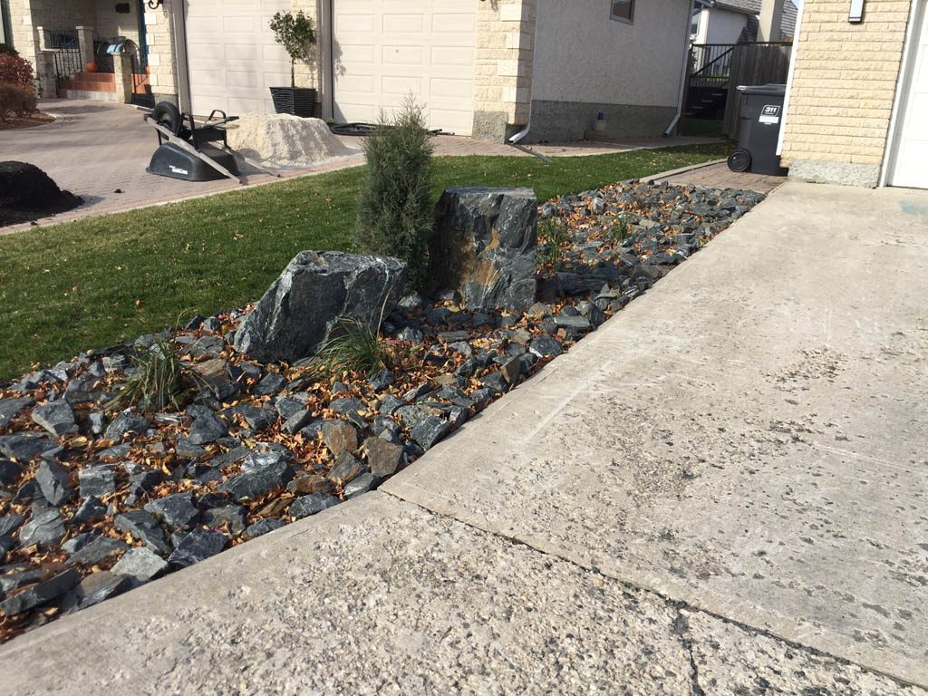 Front yard renovation with Architextures retaining wall, black granite, plants, sod